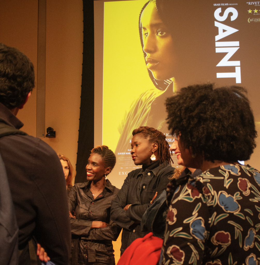 Rokhaya Diallo and Alice Diop stand next to each other as audience member converse with them.